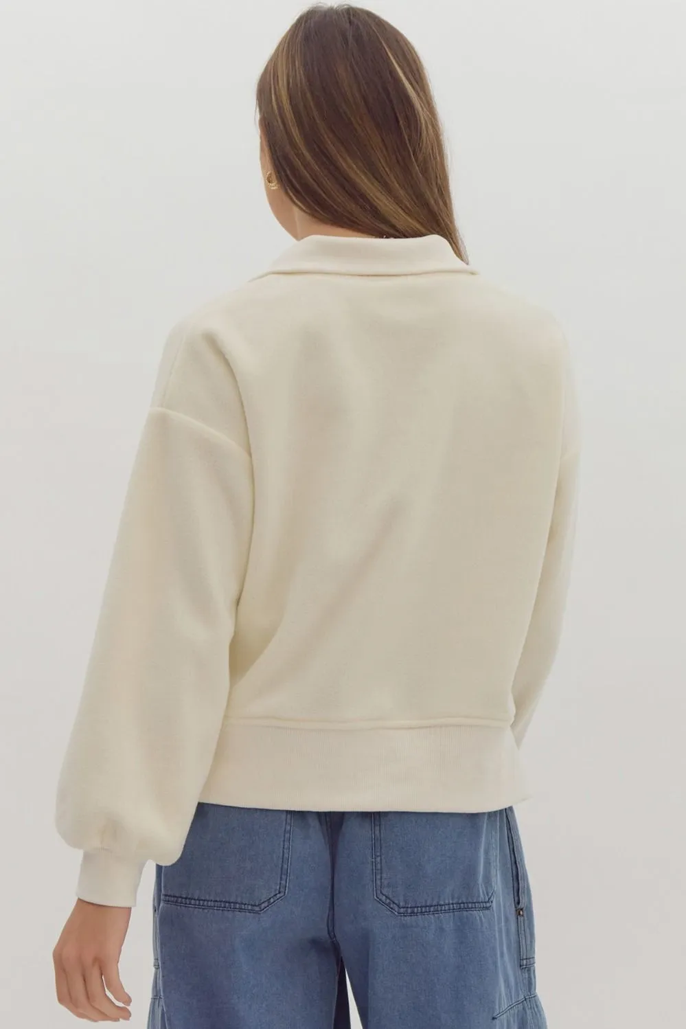  Solid long sleeve collared crop sweater featuring quarter zip detail.
